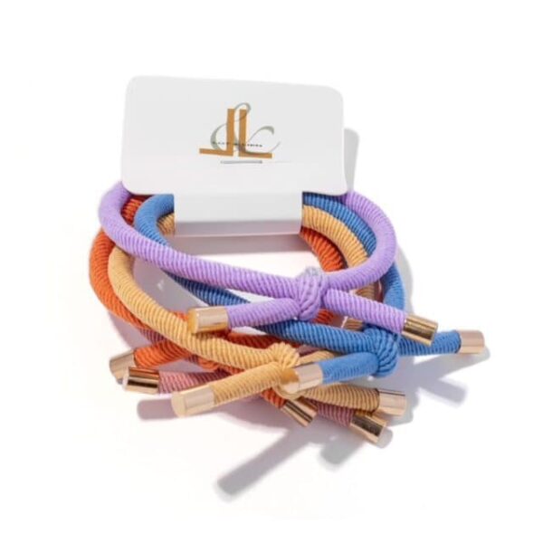 5 pastel kleurige armband/ haar elastieken. Afgewerkt met een goudkleurig detail.